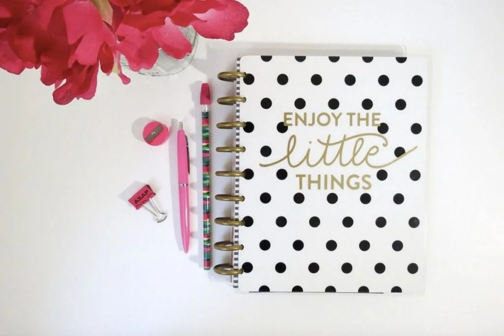Black dotty notepad with pink pens next to it