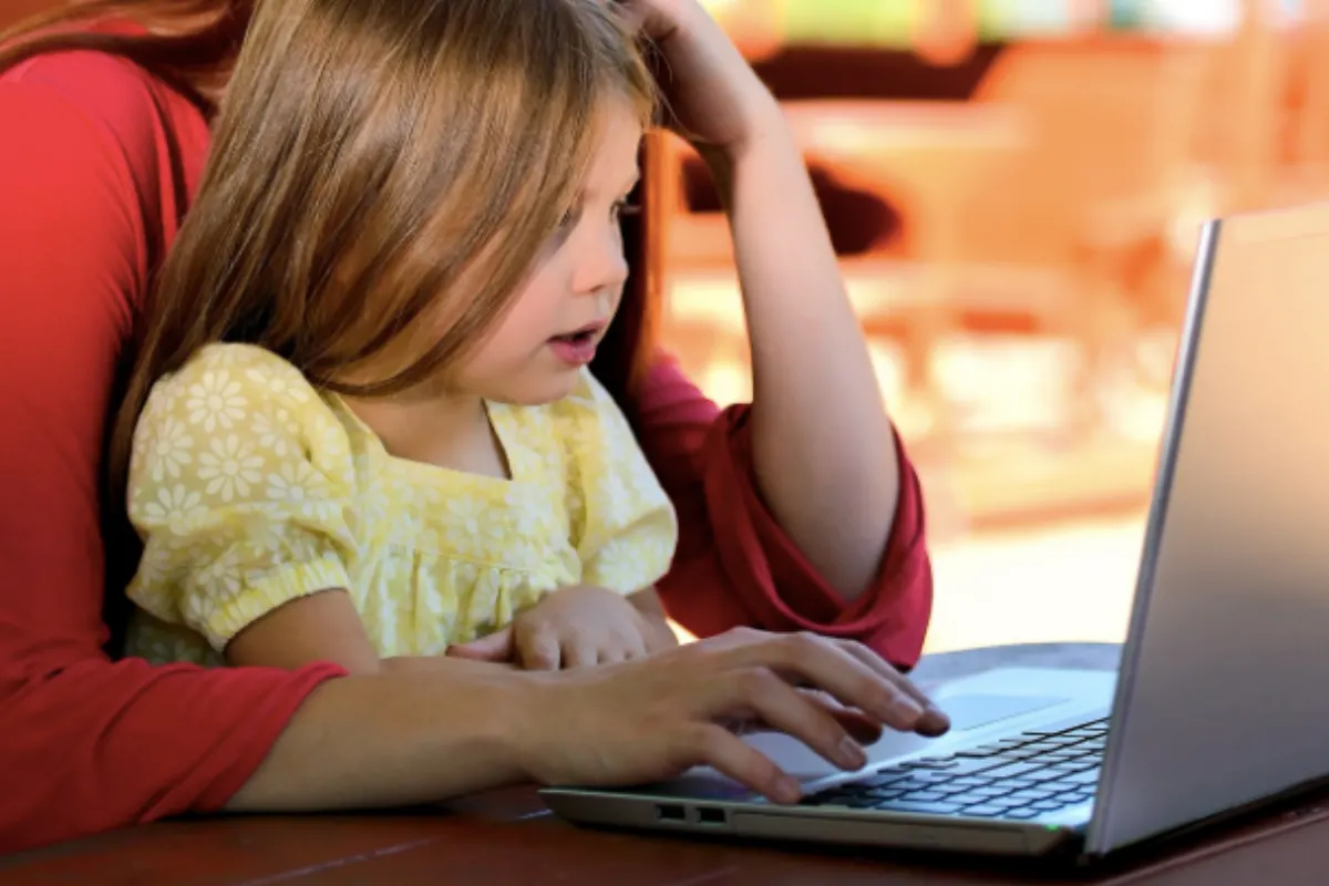 Child and mother sat at laptop