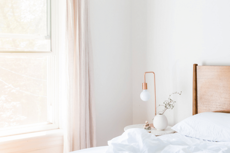 Pink curtains with a white wall and white gold lamps.