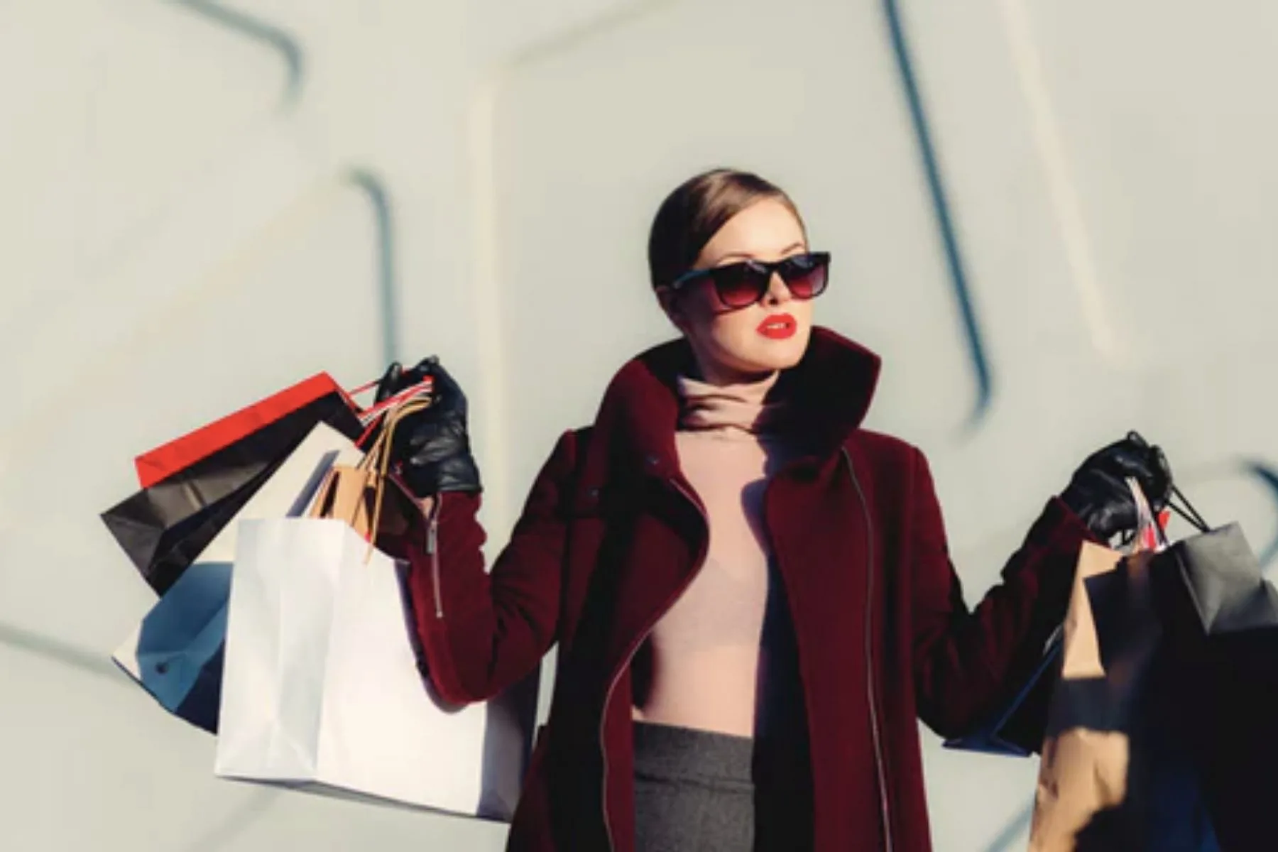 Woman in a red coat holding shopping bags