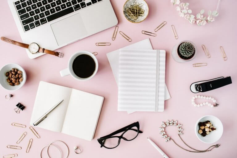 Pink background with laptop and office supplies