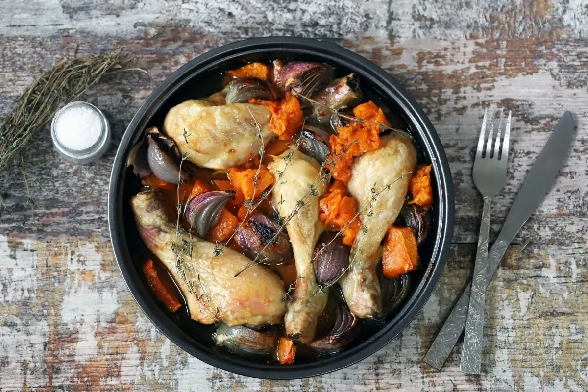 Chicken thighs in a slow cooker with carrots and red onions