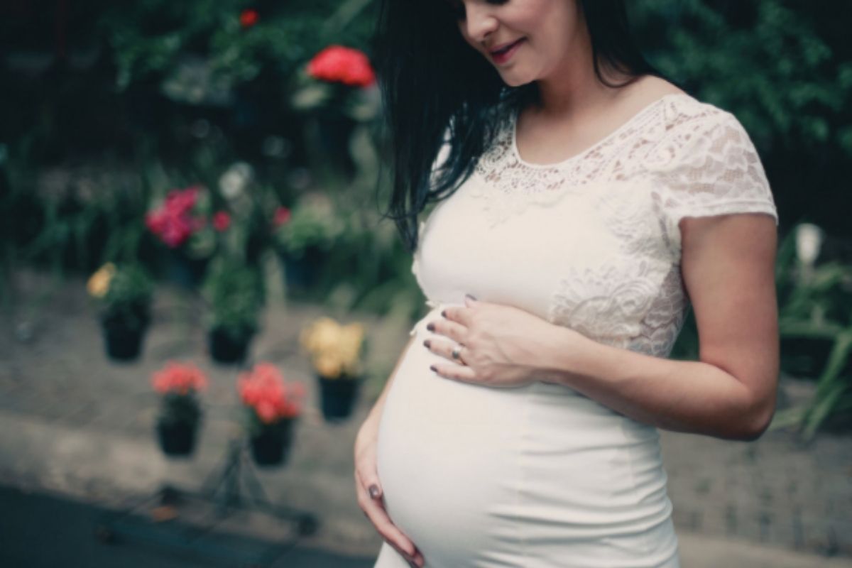 Woman in white dress who is pregnant
