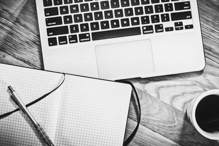 Black and white laptop with book open