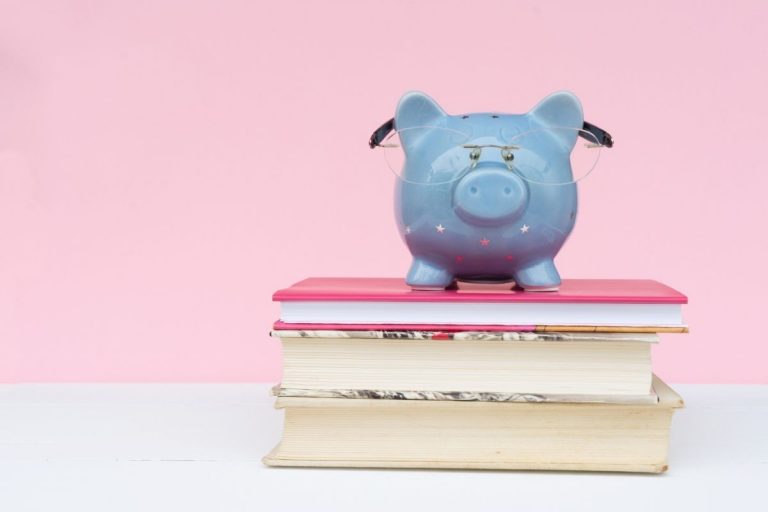 pink background with a blue pig on top of books