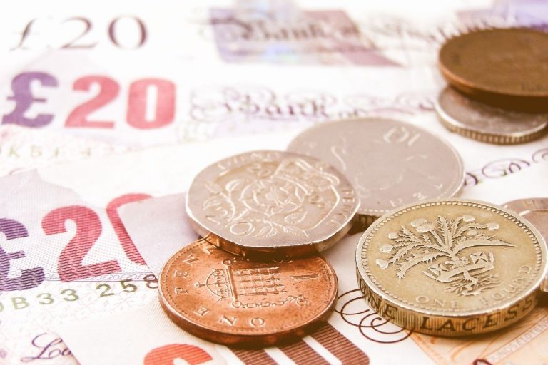Pound notes with coins on top