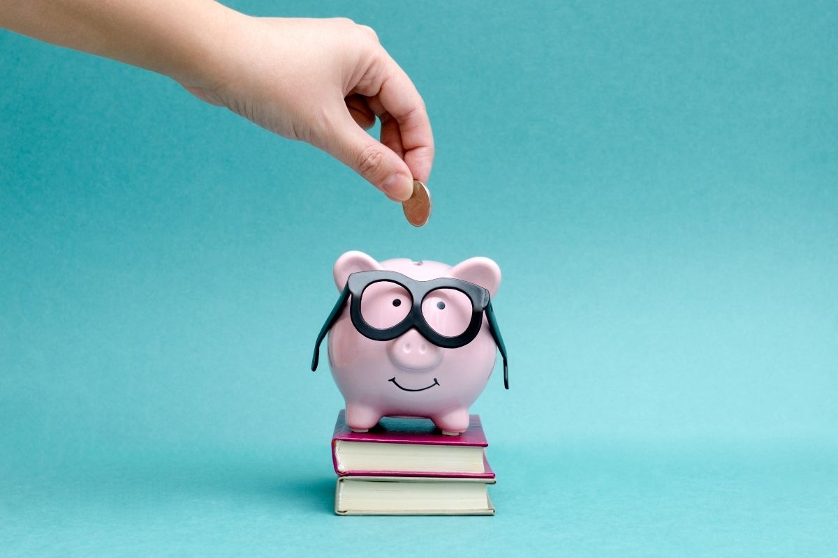Blue background with piggy bank with glasses on